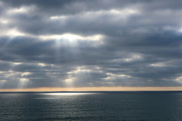 A Pacific Ocean Cloudscape with a Sun Ray on the Ocean falling through the Clouds