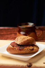 Tamale cake, also known as guajolota, is a tamale placed inside a cake and is a typical Mexican preparation, placed on a Styrofoam plate and in turn on a piece of wood in the background a cup