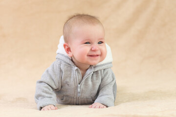 Cute joyful baby on a beige background.