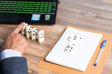 Business man creating domino effect by his hand, business strategy background image, wearing blue...