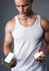 bodybuilder eating pills, steroids. Handsome Fitness Boy with medicine bottle - 787458767