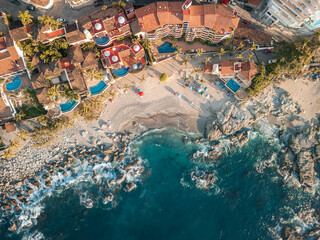 Wide aerial view of Conchas Chinas Beach in Puerto Vallarta Mexico. Villas, waves, turquoise water.