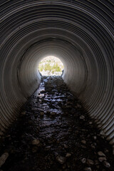A Culvert under a Road in a Desert Environment with a view of the Exit - obrazy, fototapety, plakaty