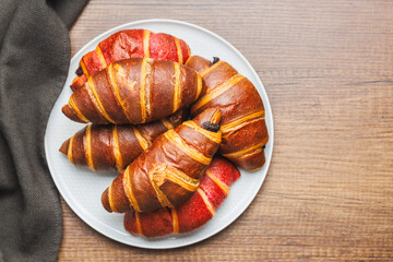 Freshly Baked fruity and Chocolate Croissants on plate on kitchen table. Top view. - 787469353