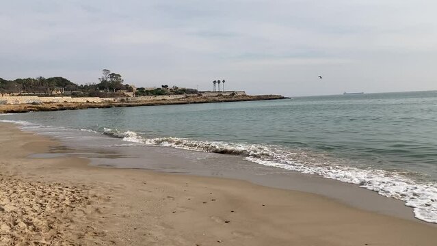 Beach in Tarragona with buildings in distance 