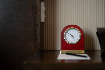 The antique semicircular clock in red and gold is simply placed on the sideboard.