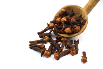 Dry cloves in wooden scoop isolated on white background with clipping path. Top view. Flat lay. selective focus.