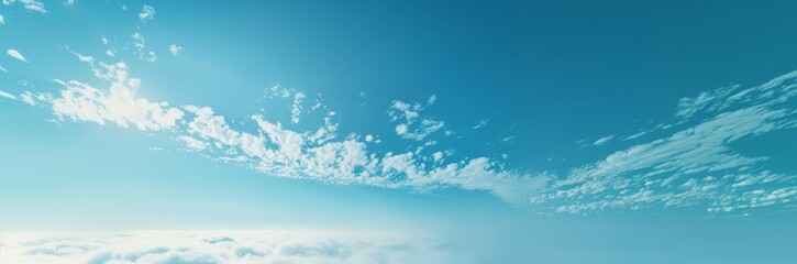 Naklejka na ściany i meble Wide panoramic image of a peaceful blue sky with wispy white clouds, invoking a sense of calm.