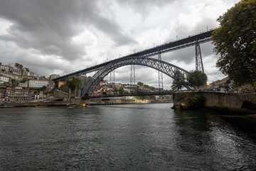Luis I Bridge from the west side from the river level - storm clouds - yellow boat for transporting barrels - obrazy, fototapety, plakaty