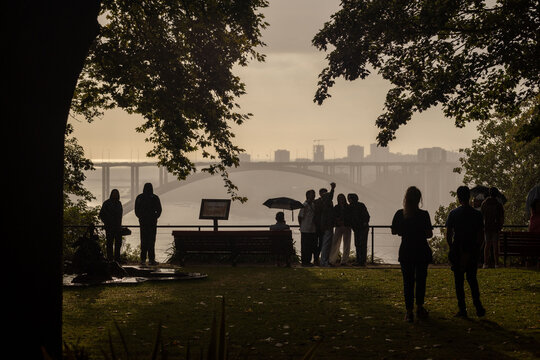 People in the park watching the sunset with the Ponte da Arrabida bridge in the background