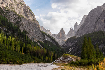 Scenic hiking trail along alpine stone field in panoramic valley Fischleintal near Moos. Panoramic view of majestic mountain ridges of Sexten Dolomites in Italian Alps. Wanderlust. Tranquil peaceful