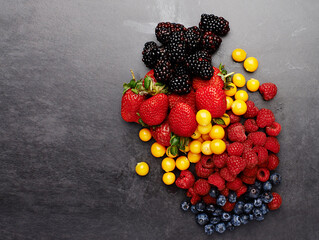 Group, above and fruit by dark background for fresh, smoothie and vegan diet on table with...