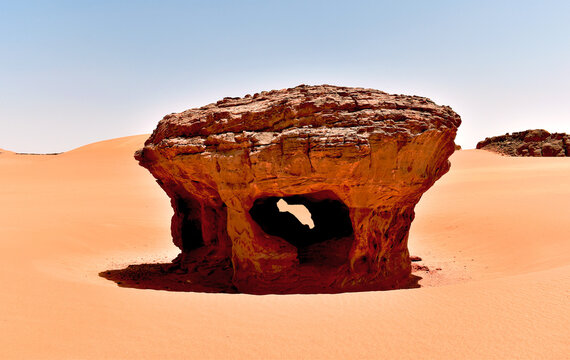 A natural rock formation in the Sahara, a weathered orange rock in the Tassili N'Ajjer National Park, Tadrart Rouge, Algeria.