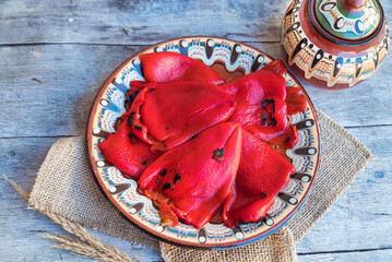 Baked red peppers in traditional Bulgarian plate 