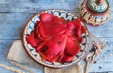 Baked red peppers in traditional Bulgarian plate 