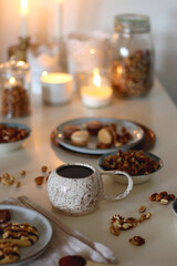 Cup of tea or coffee, cookies, macaroons, chocolate, various nuts and cocoa powder on white background. Selective focus.