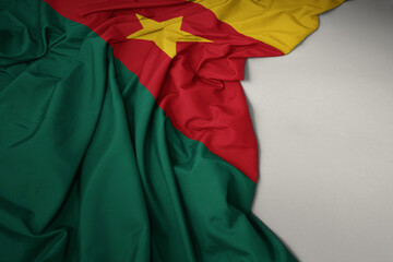 waving national flag of cameroon on a gray background.