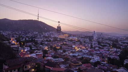 Drone point of view in evening illuminated Tbilisi - obrazy, fototapety, plakaty