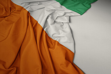 waving national flag of cote divoire on a gray background.