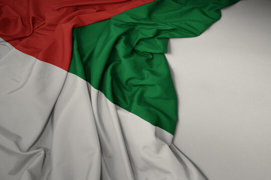 waving national flag of madagascar on a gray background.