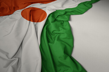 waving national flag of niger on a gray background. - obrazy, fototapety, plakaty