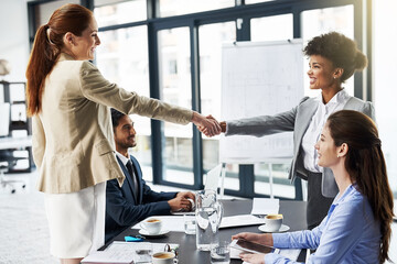 Business woman, handshake and meeting with partnership for introduction, greeting or agreement at office. Happy group or employees shaking hands for deal, b2b or teamwork in boardroom at workplace