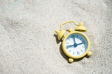 Fototapeta na wymiar beautiful alarm clock in the sand by the sea background