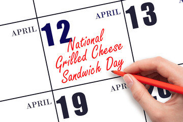 April 12. Hand writing text National Grilled Cheese Sandwich Day on calendar date. Save the date.