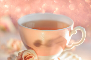 Close-up of a pink porcelain mug. Blurred background, bokeh. Soft focus, natural light