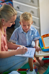 Mother, young child and checklist in bedroom for learning, motor skills and development in...