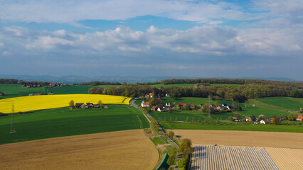 Obraz premium Aerial drone view of yellow rapeseed fields in German countryside