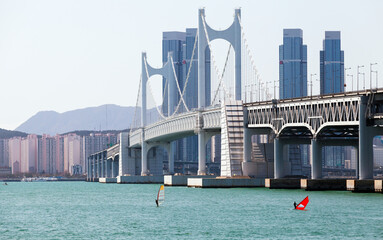 Windsurfers are near the suspension bridge located in Busan