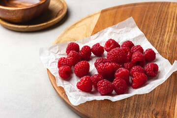 Raspberries on a white paper on a light background