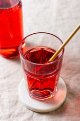 Red berries and fruits drink in the glass on the light background.
