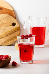 Raspberry drink in the glass on the gray background.
