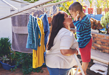 Mother, child and love for hanging washing with kiss or funny face with laundry housework, backyard...