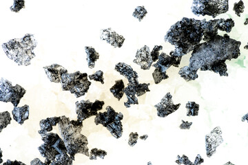 Heap of small stones of black salt on top of white salt, used in cooking seasonings