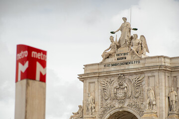 Red subway station identification symbol with arc of Rua Augusta in the background.Lisbon-Portugal