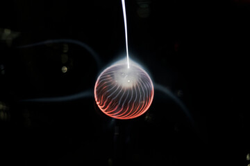 Electricity plasma sphere ball isolated on a black background with ray going out of it