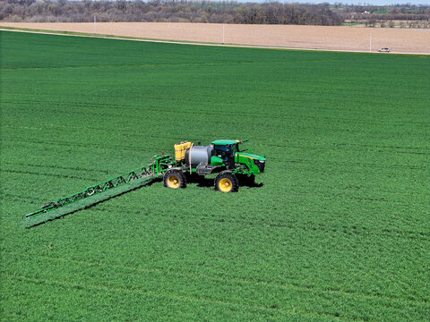 Spring Grove, WI - USA -  April 15, 2024 John Deere R4038 self propelled sprayer applying herbicide to winter wheat