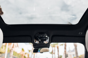 Panoramic sunroof at the car and blue sky and palms. Clean sunroof and view of the sky from the...
