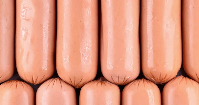 Mini sausage video background. Food background. Mini hotdogs or cocktails sausage. Top view video of Mini sausage background