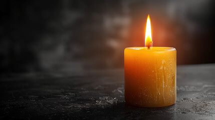 Lit candle on a dark background