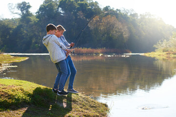 Happy, young boys and nature with fishing and bonding together at a lake on summer vacation for fun adventure. Friends, kids and smile to play outdoor near water for recreation or hobby on holiday © peopleimages.com
