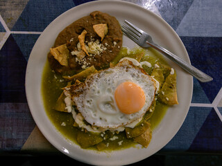 Typical chilaquiles mexican food for breakfast in Mexico. Top down view on table flat lay.