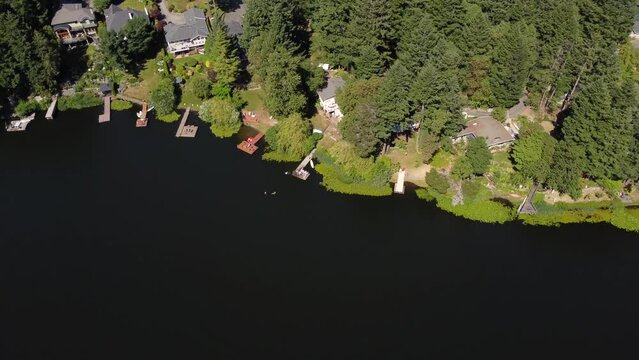 Victoria British Columbia Canada, July 17 2023: Cabins and docks line a lakeshore aerial looking down shot.
