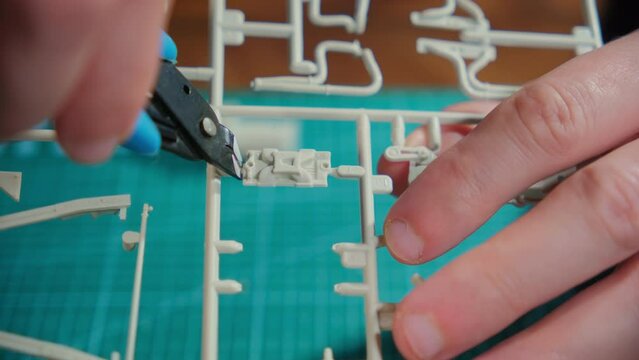 Close up footage of hands of Man assembler plastic model at table. hobby time