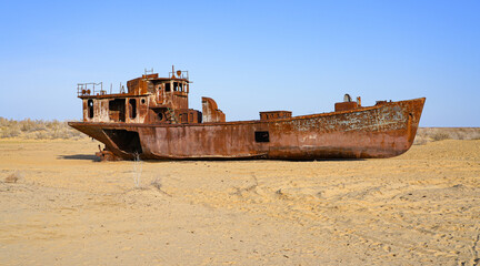 Fototapeta premium Rusty shipwreck lying on the seabed of the dried-up Aral Sea in Moynaq (or Muynak), a former fishing town in Karakalpakstan, Uzbekistan