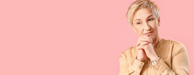 Thoughtful mature woman on pink background, closeup