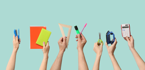 Many hands with office stationery on color background